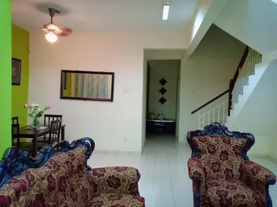 a living room with two chairs and a staircase at Muslim Dinaim Homestay in Tanjung Malim