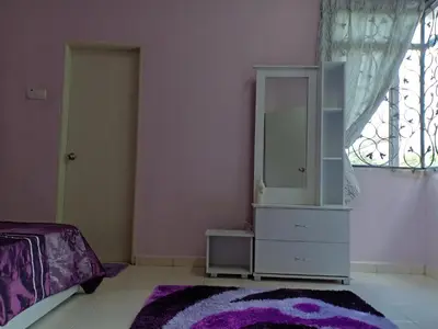 a bedroom with a white dresser and a mirror at Muslim Dinaim Homestay in Tanjung Malim