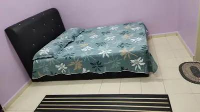 a bed in a room with a blue blanket on it at Muslim Dinaim Homestay in Tanjung Malim