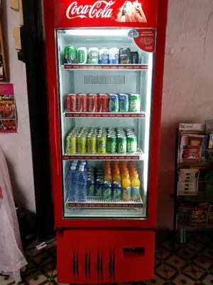 an open coca cola refrigerator filled with lots of drinks at Muntri House by Virtue Hospitality in George Town