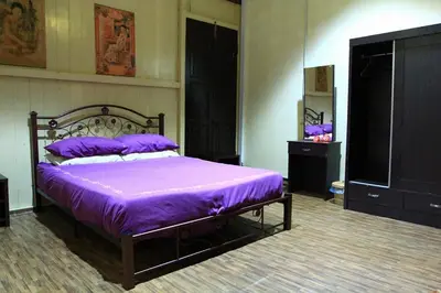 a bedroom with a bed with purple sheets on it at Muntri House by Virtue Hospitality in George Town