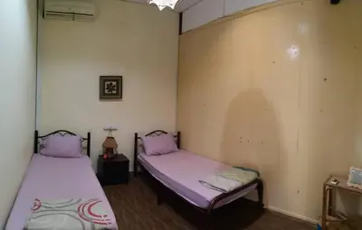 two beds in a room with purple sheets at Muntri House by Virtue Hospitality in George Town