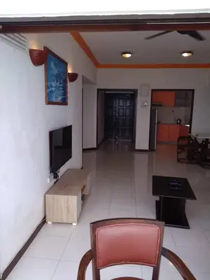 a living room with a couch and a tv and a chair at The Barn private home @ Sri Sayang Apartment in Batu Ferringhi