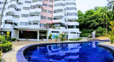 a hotel with a swimming pool in front of a building at The Barn private home @ Sri Sayang Apartment in Batu Ferringhi