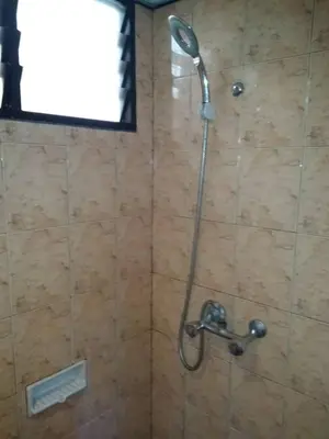 a shower with a shower head in a bathroom at The Barn private home @ Sri Sayang Apartment in Batu Ferringhi