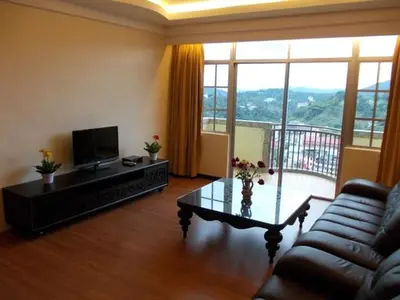 a living room with a couch and a coffee table at Bali Style Apartment @ Imperial Court in Cameron Highlands