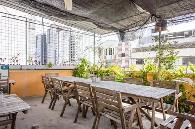 a wooden table and chairs in a restaurant with buildings at Nice Inn in George Town