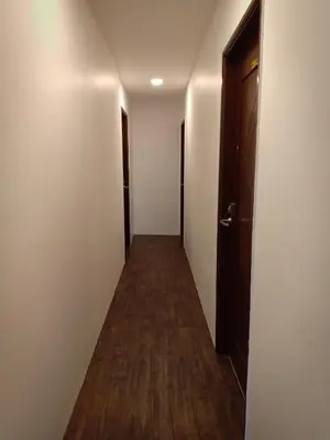 a hallway with two doors and a wooden floor at Nice Inn in George Town