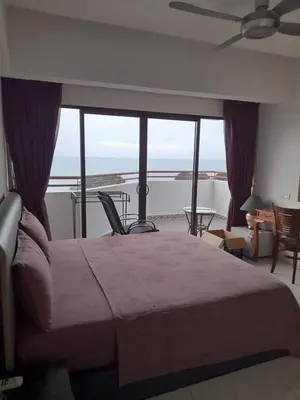 a bedroom with a bed and a view of the ocean at Susie's VIP Resort Seaview Suite at Sri Sayang in Batu Ferringhi