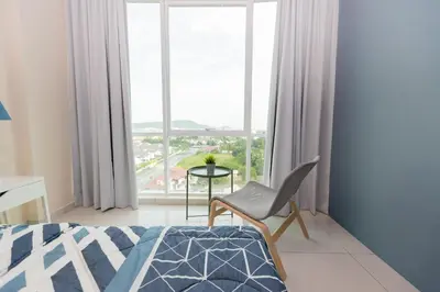 a bedroom with a bed and a chair and a window at Cozy Home with Spectacular View in Bayan Lepas