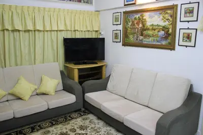 a living room with a couch and a flat screen tv at Macallum Budget Muslim Homestay in George Town