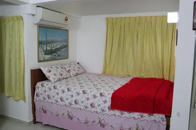 a bedroom with a bed with a red blanket at Macallum Budget Muslim Homestay in George Town