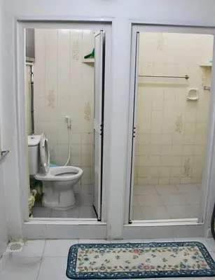 a bathroom with a toilet and a shower with a door at Macallum Budget Muslim Homestay in George Town