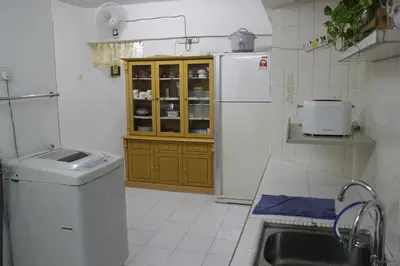 a small kitchen with a sink and a refrigerator at Macallum Budget Muslim Homestay in George Town
