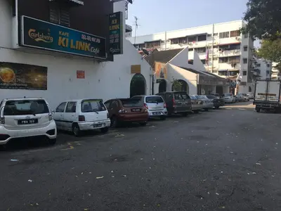 a row of cars parked on the side of a street at Macallum Budget Muslim Homestay in George Town