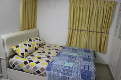 a bedroom with a bed with a quilt on it at Macallum Budget Muslim Homestay in George Town