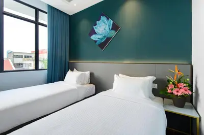 two beds in a room with blue walls at SAVV HOTEL in George Town