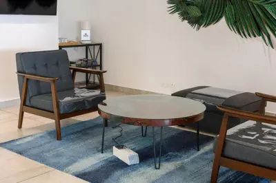 a living room with a table and a chair and a bed at SAVV HOTEL in George Town