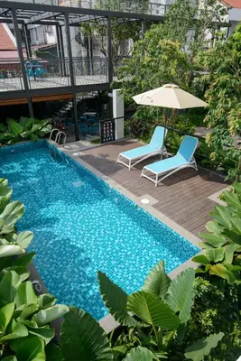 a swimming pool with two chairs and an umbrella at SAVV HOTEL in George Town