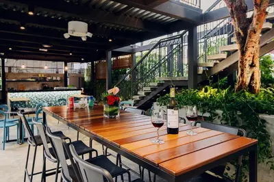 a wooden table with two glasses of wine on it at SAVV HOTEL in George Town
