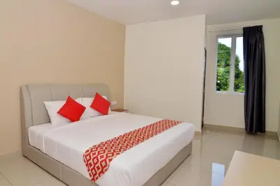 a bedroom with a bed with red pillows and a window at Hotel Raub Agro in Raub