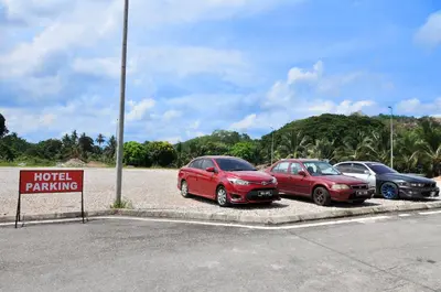 three cars parked in a parking lot with a hotel parking sign at Hotel Raub Agro in Raub