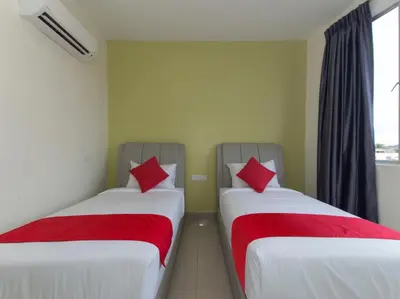 two beds in a room with red pillows on them at Hotel Raub Agro in Raub