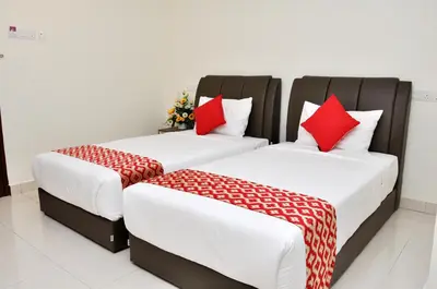 two beds with red pillows in a room at Hotel Raub Agro in Raub