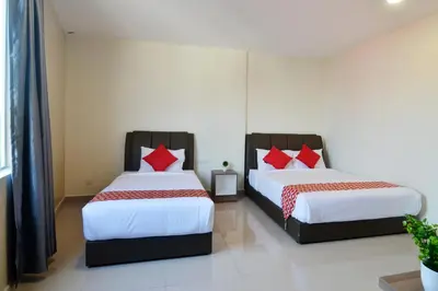 two beds with red pillows in a room at Hotel Raub Agro in Raub