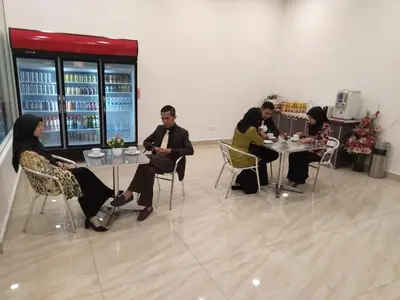a group of people sitting at tables in a room at Hotel Raub Agro in Raub