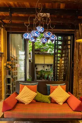 a couch with colorful pillows sitting in front of a window at Spices Hotel in George Town