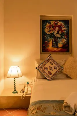 a bedroom with a bed with a painting on the wall and a lamp at Spices Hotel in George Town