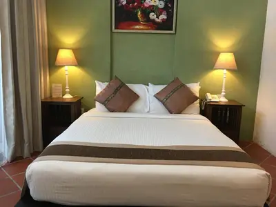 a bedroom with a large white bed with two lamps at Spices Hotel in George Town