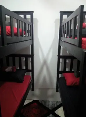 a bedroom with two bunk beds with red sheets at MUSLIM 2 BED ROOM APARTMENT GOLDEN HILL in Brinchang