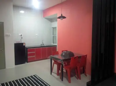 a kitchen with red walls and a table and red chairs at MUSLIM 2 BED ROOM APARTMENT GOLDEN HILL in Brinchang
