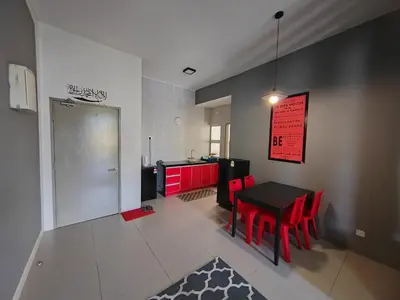 a kitchen with red cabinets and a black table and red chairs at MUSLIM 2 BED ROOM APARTMENT GOLDEN HILL in Brinchang