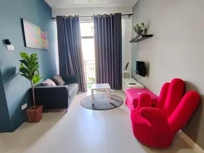 a living room with a red chair and a couch at MUSLIM 2 BED ROOM APARTMENT GOLDEN HILL in Brinchang