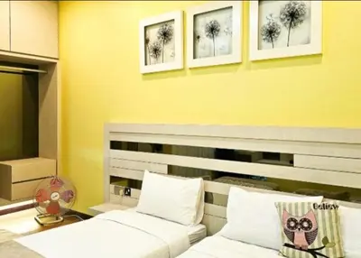 two beds in a room with yellow walls at Sekinchan Theme Design Penthouse 16-30Ppax \u4e3b\u9898\u9876\u5c42\u516c\u5bd3\u6c11\u5bbf in Sekincan