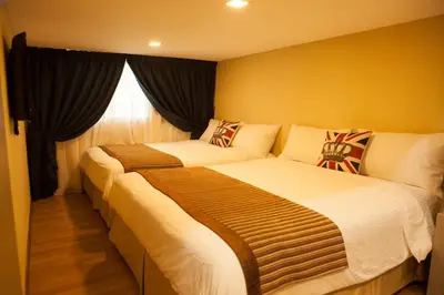 two beds in a hotel room with a window at Sekinchan Theme Design Penthouse 16-30Ppax \u4e3b\u9898\u9876\u5c42\u516c\u5bd3\u6c11\u5bbf in Sekincan
