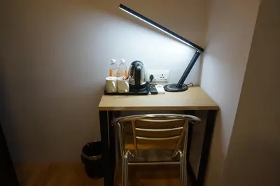 a desk with a lamp and a chair in a room at Super 8 Hotel @ Bayan Baru in Bayan Lepas