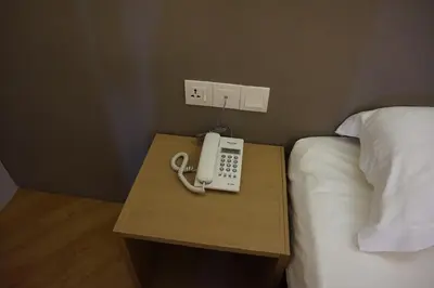a telephone on a table next to a bed at Super 8 Hotel @ Bayan Baru in Bayan Lepas