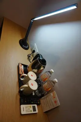 a table with a lamp and some bottles on it at Super 8 Hotel @ Bayan Baru in Bayan Lepas