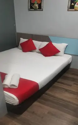 a bed with red and white pillows on it at Lucky Hotel in Sungai Petani