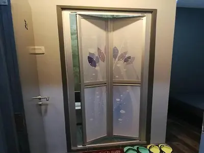 a glass cabinet with a door in a room at Lucky Hotel in Sungai Petani