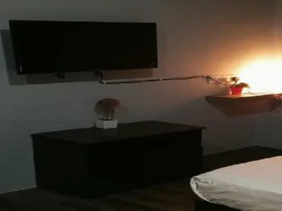 a bedroom with a tv on the wall and a bed at Lucky Hotel in Sungai Petani