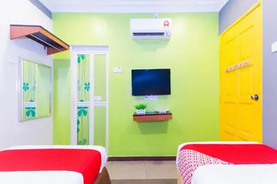 a room with two beds and a tv on the wall at Hotel O Comfort in Ipoh