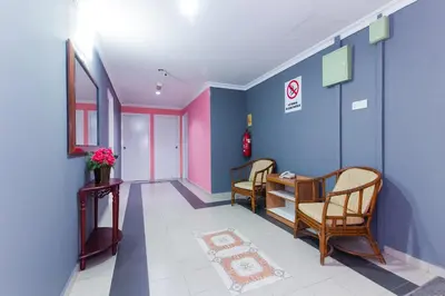 a hallway with chairs and a table in a building at Hotel O Comfort in Ipoh