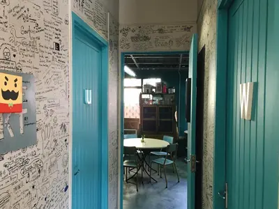 a room with a table and a blue door at Wogoxette Upstairs, A Private Kampung Stay In Cameron Highlands in Cameron Highlands
