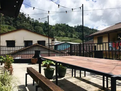 a wooden table and benches on a patio at Wogoxette Upstairs, A Private Kampung Stay In Cameron Highlands in Cameron Highlands