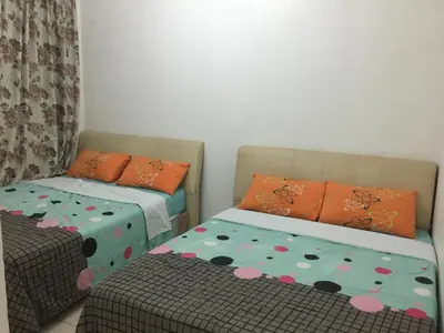 a room with two beds and a table and a couch at Cameron Supersave Apartment @ Crown Imperial Court in Brinchang